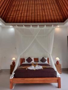 a bedroom with a bed with a canopy at Pondok Kukuh villa Sidemen in Sidemen +31 photos