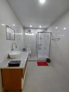 a white bathroom with a sink and a shower at Pondok Kukuh villa Sidemen in Sidemen