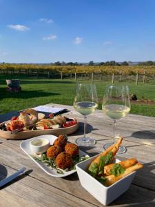 a table with plates of food and glasses of wine at Old Maffra Cottage in Maffra