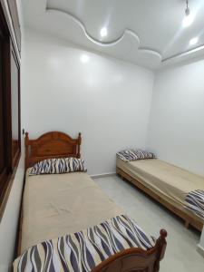 2 Betten in einem Zimmer mit weißen Wänden in der Unterkunft Apartment for rent in Chefchaouen