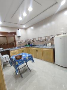 cocina con mesa y nevera blanca en Apartment for rent, en Chefchaouen