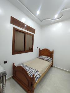 een slaapkamer met een houten bed en een spiegel bij Apartment for rent in Chefchaouene