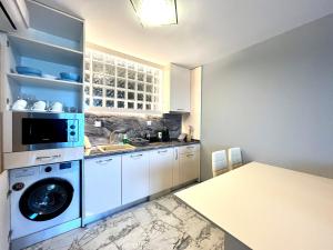 a kitchen with a washing machine and a sink at Aurora apartments on the beach in Obzor
