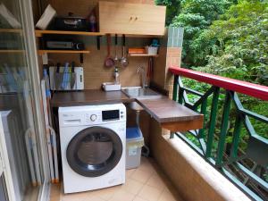 a washing machine and a sink on a balcony at 知本溫泉家 in Hua-yüan