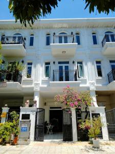 a large white building with balconies and flowers at Aroma home in Da Nang