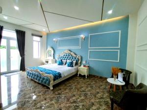 a bedroom with a blue wall with a bed and a couch at Aroma home in Da Nang +47 photos