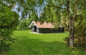 ein schwarzes Haus mit rotem Dach auf einem grünen Hof in der Unterkunft 3 Bedroom Cozy Home In Oksbl in Oksbøl