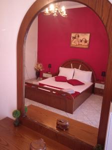a bedroom with a bed with a red wall at Montagna e mare in Kallirakhi