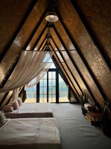 - une chambre mansardée avec 2 lits et une fenêtre dans l'établissement บ้านหิ่งห้อยผาหมี Baanhinghoi phamee, à Mae Sai