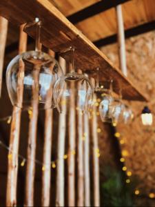 a chandelier with wine glasses hanging from a ceiling at บ้านหิ่งห้อยผาหมี Baanhinghoi phamee in Mae Sai