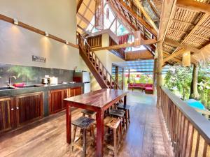 cocina abierta y comedor con mesa de madera en Emerald House Village en General Luna