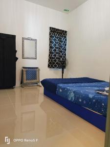 a bedroom with a blue bed and a mirror at ASFA Homestay Kuching in Kuching +16 photos