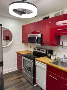 a kitchen with red cabinets and a stove top oven at Atlanta Penthouse King/ Queen Bd in Atlanta
