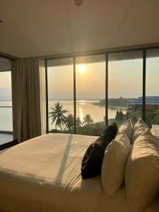 a bedroom with a bed with a view of the ocean at M2 Hotel Waterside in Phayao