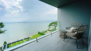 ein Balkon mit Stuhl und Blick aufs Wasser in der Unterkunft M2 Hotel Waterside in Phayao