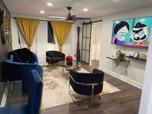 a living room with blue chairs and a painting on the wall at Atlanta Penthouse King/ Queen Bd in Atlanta