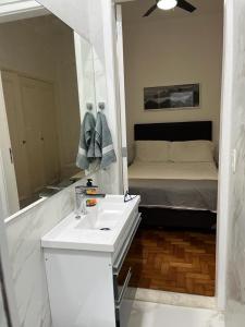 baño con lavabo, espejo y cama en Amazing in Ipanema by Verlaine Adami, en Río de Janeiro