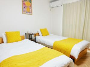 大阪市にあるSummit Villa 100sqm Osaka Nakazakicho Stationのベッド2台が隣同士に設置された部屋です。