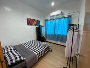 a bedroom with a bed and a blue window at Lisa Homestay Sandakan in Sandakan