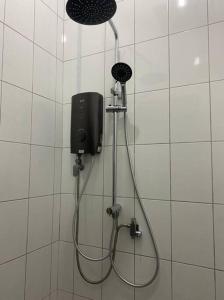 a shower in a bathroom with a shower head at Lisa Homestay Sandakan in Sandakan