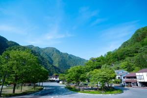 una calle en un pueblo con montañas en el fondo en LOCOMOTION COFFEE AND BED en Tateyama