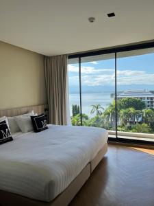 ein Schlafzimmer mit einem großen Bett und einem großen Fenster in der Unterkunft M2 Hotel Waterside in Phayao + 78 Fotos