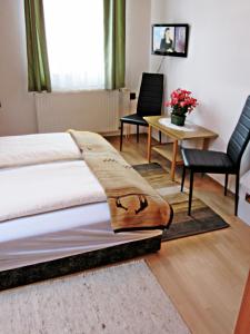 1 dormitorio con 1 cama, mesa y sillas en Zsuzsa Panzió, en Balatonfüred