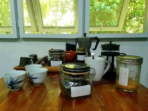 a table with jars and cups on a wooden table at Private Nature Retreat w/Brick Oven & Hiking in Lipa