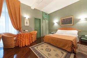 a bedroom with a bed and a chair and a table at Hotel Villa Giulia in Tortona