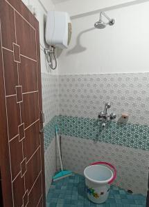 ein Badezimmer mit einem Eimer auf dem Boden und einem Waschbecken in der Unterkunft Valley View Homestay in Darjeeling
