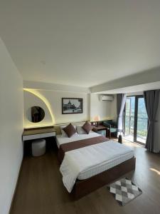 a bedroom with a large bed and a large window at Sapa Royal Orbit Hotel in Sa Pa