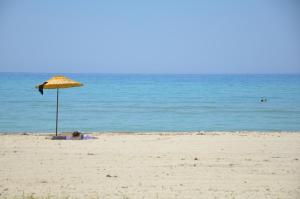 uma pessoa deitada sob um guarda-sol na praia em Villa Plaj em Kusadasi