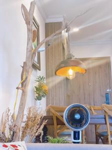een kamer met een tafel met een licht en een ventilator bij Homestay Ecopark in Kim Quan