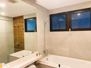 een badkamer met een bad, een douche en een wastafel bij Homestay Ecopark in Kim Quan