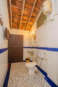 a bathroom with a toilet and a sink at Nature's Nest Eco Resort Goa, Near Dudhsagar Waterfalls in Molem