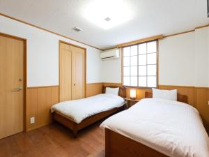 um quarto com duas camas e uma janela em Travel Inn Kofu em Kofu