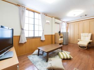 - un salon avec une table et une télévision dans l'établissement Travel Inn Kofu, à Kōfu