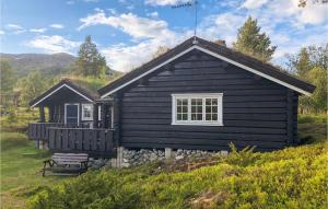 a black house with a bench in front of it at Awesome Home In Hvringen With Sauna in Høvringen