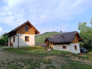a small white house with a wooden roof at Dolná chata u Bratríkov in Haligovce