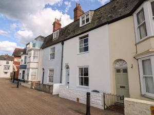 uma fila de casas brancas numa rua em Harbourside Cottage em Weymouth