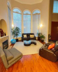 uma grande sala de estar com sofás e uma lareira em Green Leaf B&B em West Kelowna