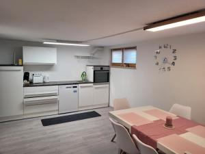 eine Küche und ein Esszimmer mit einem Tisch und einer Uhr in der Unterkunft Haus Lärche - Die Ferienwohnung in Wolfratshausen
