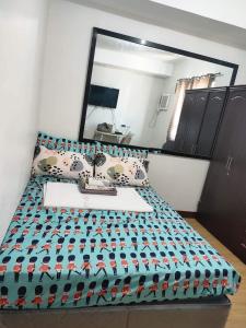a bed in a room with a large mirror at Studio unit at Mesaverte Residence in Cagayan de Oro