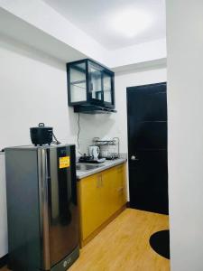 a kitchen with a stainless steel refrigerator and a black cabinet at Studio unit at Mesaverte Residence in Cagayan de Oro
