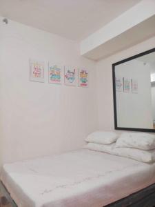 a bedroom with white walls and a mirror on the wall at Studio unit at Mesaverte Residence in Cagayan de Oro