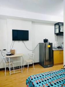 a room with a kitchen and a table and a tv at Studio unit at Mesaverte Residence in Cagayan de Oro