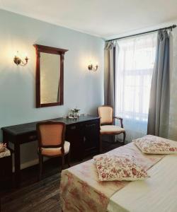 1 dormitorio con 2 camas, escritorio y espejo en Taanilinna Hotell en Tallin
