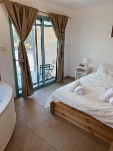 a bedroom with a bed and a view of the ocean at heart of the golan heights cabin -בקתה במטע in Eli Ad