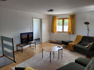 un soggiorno con divano e tavolo di Haus Lärche - Die Ferienwohnung a Wolfratshausen