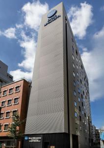 un grand bâtiment avec une horloge sur son côté dans l'établissement Best Western Hotel Fino Tokyo Akihabara, à Tokyo
